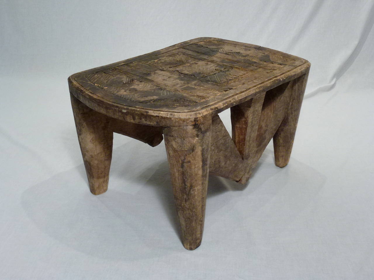 Antique African Nupe stool from Nigeria. Hand-carved from a single piece of wood, this stool boasts richly carved surfaces. Beautifully patinated surface.