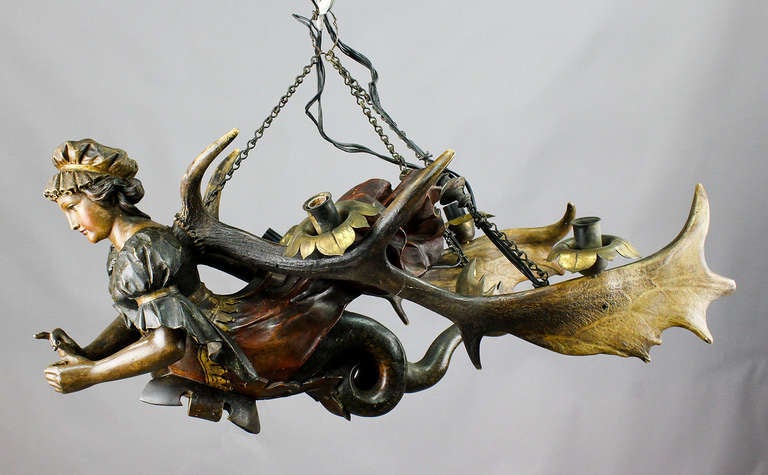antique antler chandelier, handcarved and painted lady statue between two original fallow deer antlers. named lusterweibchen or lüsterweibchen. with fishtail and helmet plate. executed ca. 1900. length figure 13.8