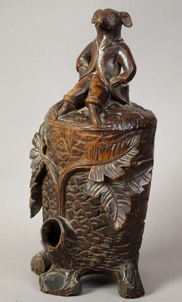 a nice wooden carved tobacco jar / humidor with a whimsical carved fox on top of the lid. on the front a hole for matches. black forest, ca. 1890