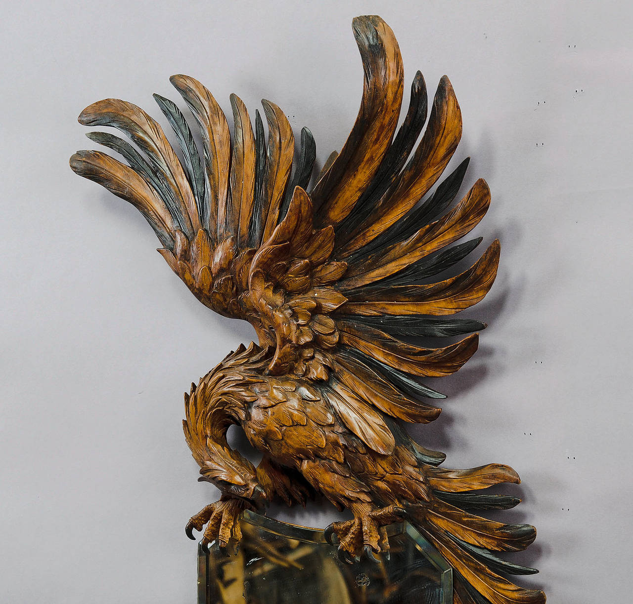 A wall mirror decorated with a hand-carved wood eagle with spread wings. An elaborate carving, executed, circa 1900.