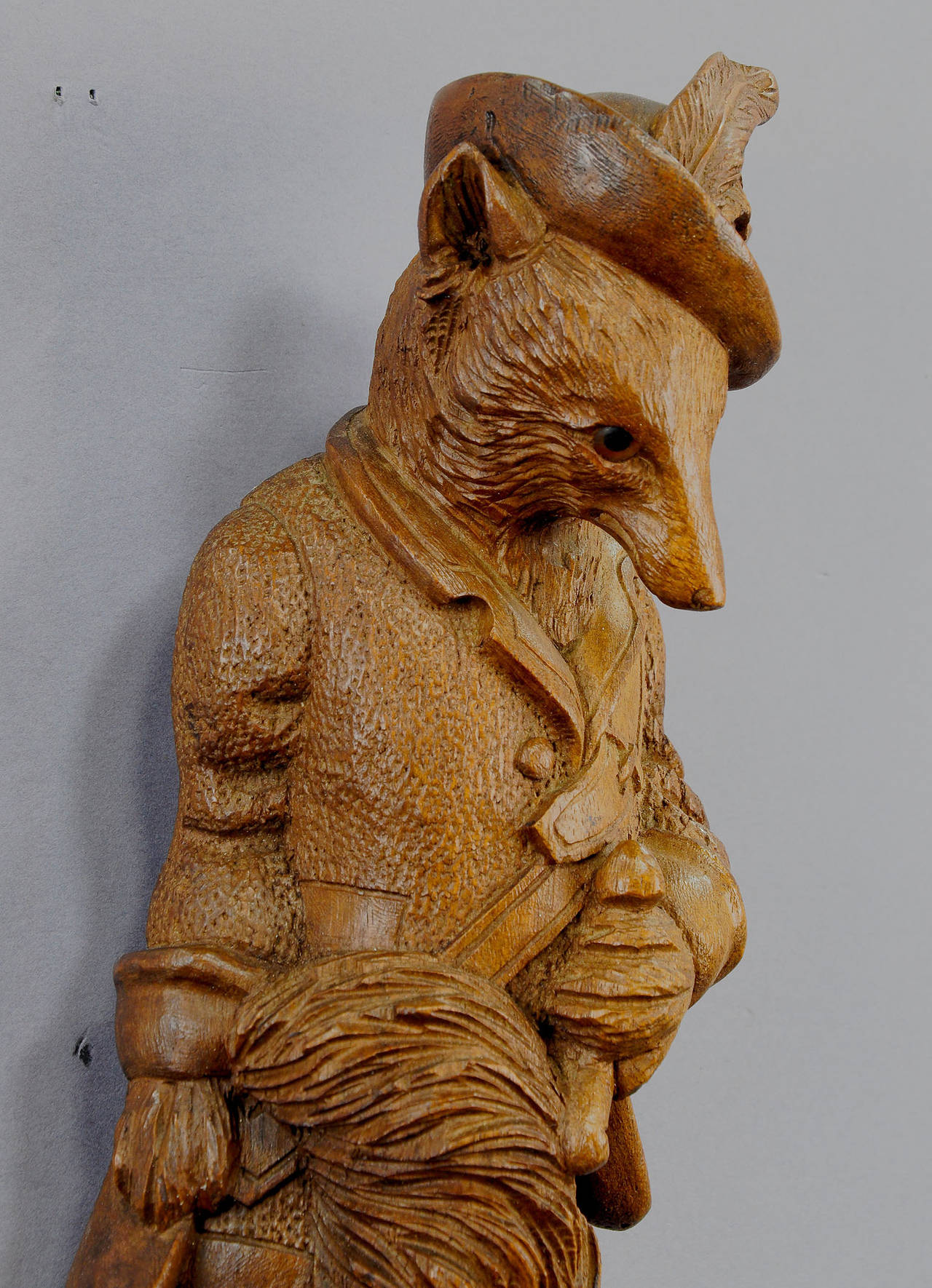 a lovely black forest carved and dressed hunting fox, with a gun strapped to his back. coat hooks made of real chamois horns. with glass eyes. Germany, Black Forest ca. 1900