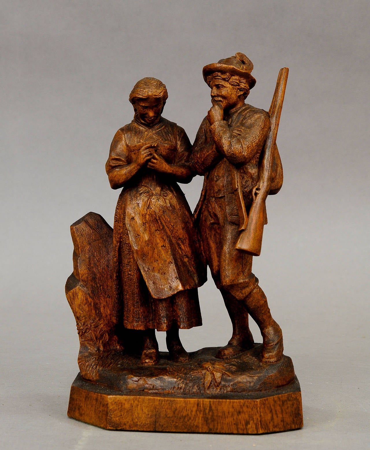 a great wooden carved statue of a hunter with his maid which got an edelweiss flower from him. a detailed and outstanding woodcarving - probably carved by johann huggler (1861-1943), swiss brienz ca. 1900.