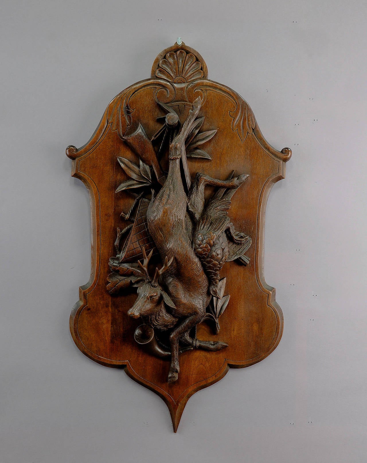 A pair of antique wooden hunting wall plaques with impressive carvings of deer, pheasant and game bag. Executed circa 1900.