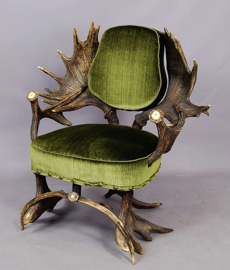 a rare antique black forest antler armchair, made of moose antlers. seat and back are covered with green velvet. executed ca. 1880, austria. unrestored original condition.
