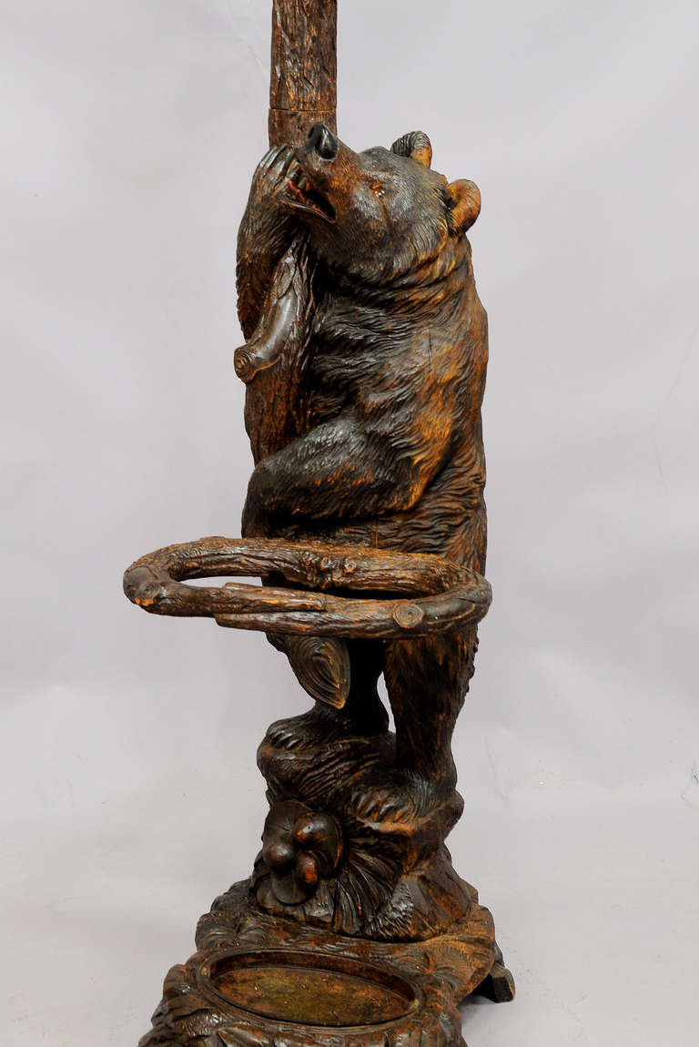 A hand-carved lindenwood bear hallstand for coats and umbrellas. The mother bear looking upwards at her cub hanging in the branches. Executed circa 1900, Swiss Brienz. Measures: Height mother bear 39.4