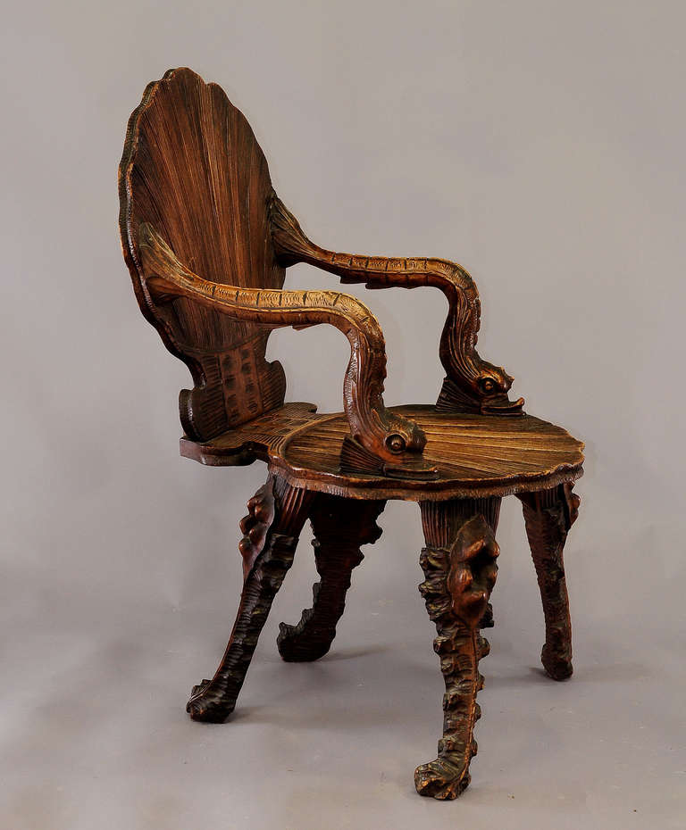Antique carved walnut armchair in grotto design. seat and backrest in the shape of a sea shell, arm rests in the shape of sea horses. Executed in Venice, Italy circa 1880.