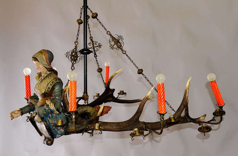 An antique antler chandelier, a hand-carved and painted statue of a Victorian lady fixed on a large pair of original stag antlers. Named Lusterweibchen or Lüsterweibchen. Executed, circa 1890. (height figure only ca. 18.9 inch. (48 cm).