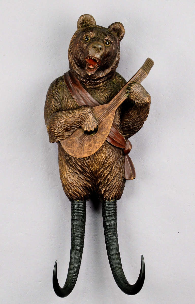 a rare whimsical handcarved mandolin playing bear whip holder / coat hook. with music work integrated in the body which starts playing when something is hanged on the chamois horns. executed by peter trauffer, swiss - brienz ca. 1890.