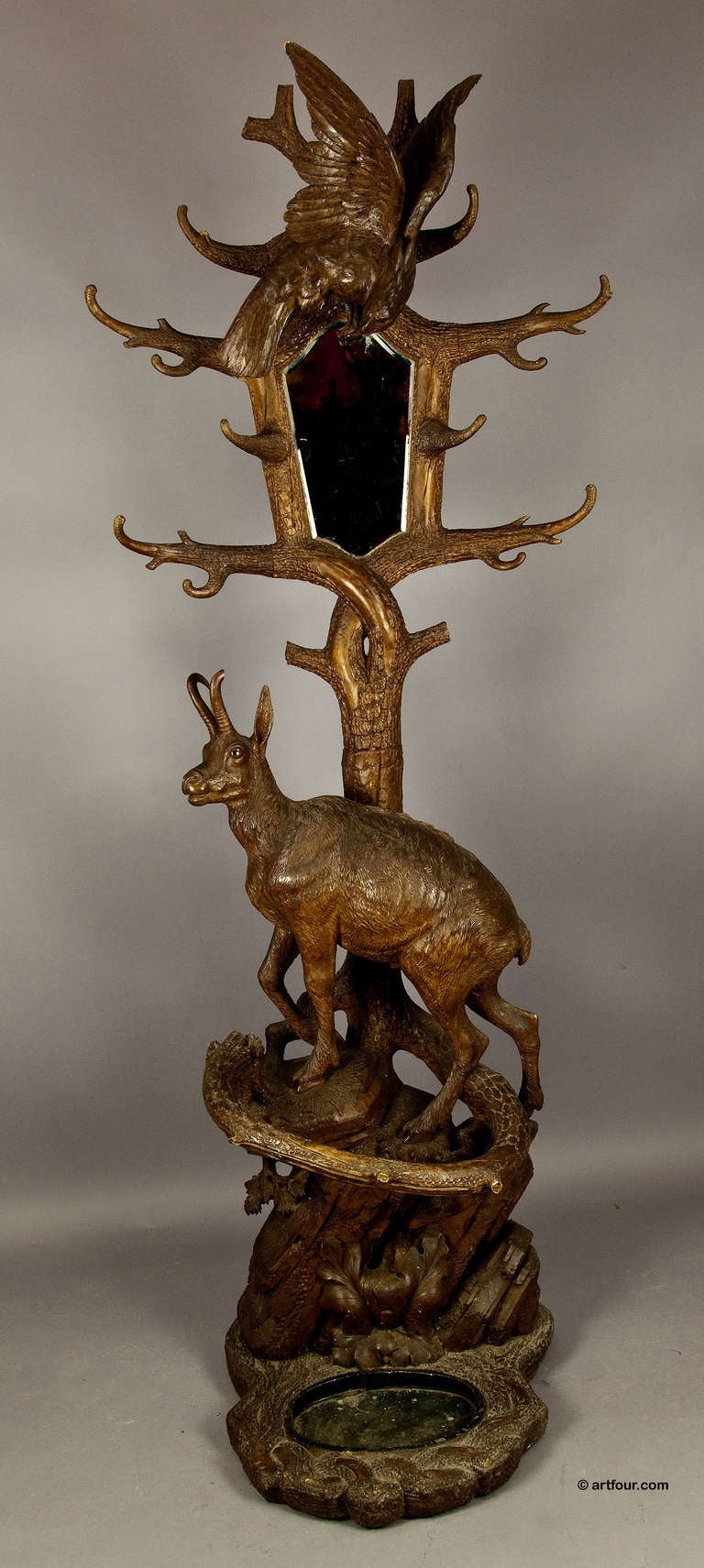 a handcarved linden wood hall stand. modelled as a life-sized chamois standing on a rocky outcrop. on the top of the mirror an eagle. swiss brienz ca. 1880.
