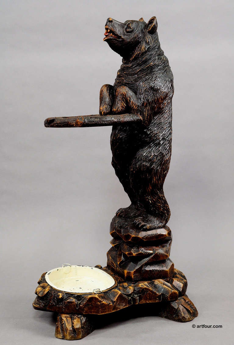 a handcarved wood umbrella/cane stand modeled as a lovely bear supporting a branch. stand with metal drip pan. executed ca. 1900, swiss brienz. a great collectors piece.