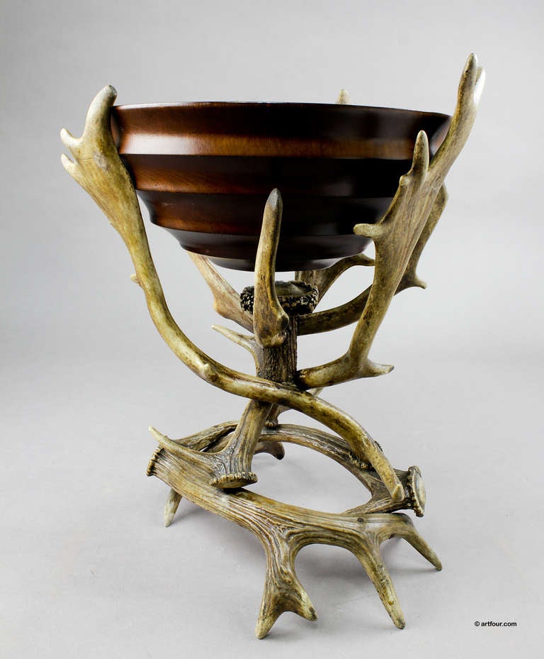 a large wooden bowl on a stand made of antlers from the deer and the fallow deer.