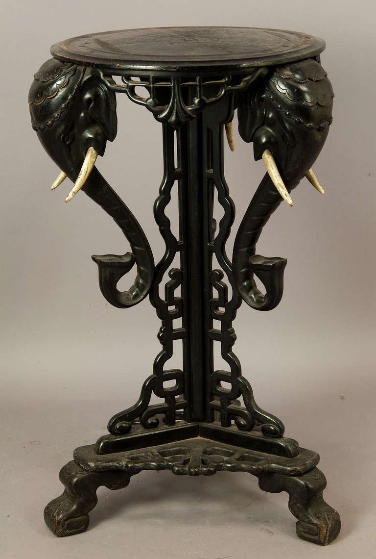 a wooden carved fantasy flower stand with elefant heads. tusks also made of wood. china ca. 1900.