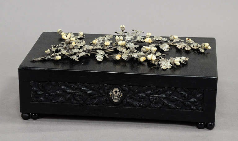 a rare handcarved casket made of oak wood. the lid decorated with a fine sterling application in the shape of oak branches and leaves. the acorns are made of wild boar teeth (grandeln). germany, black forest ca. 1900.