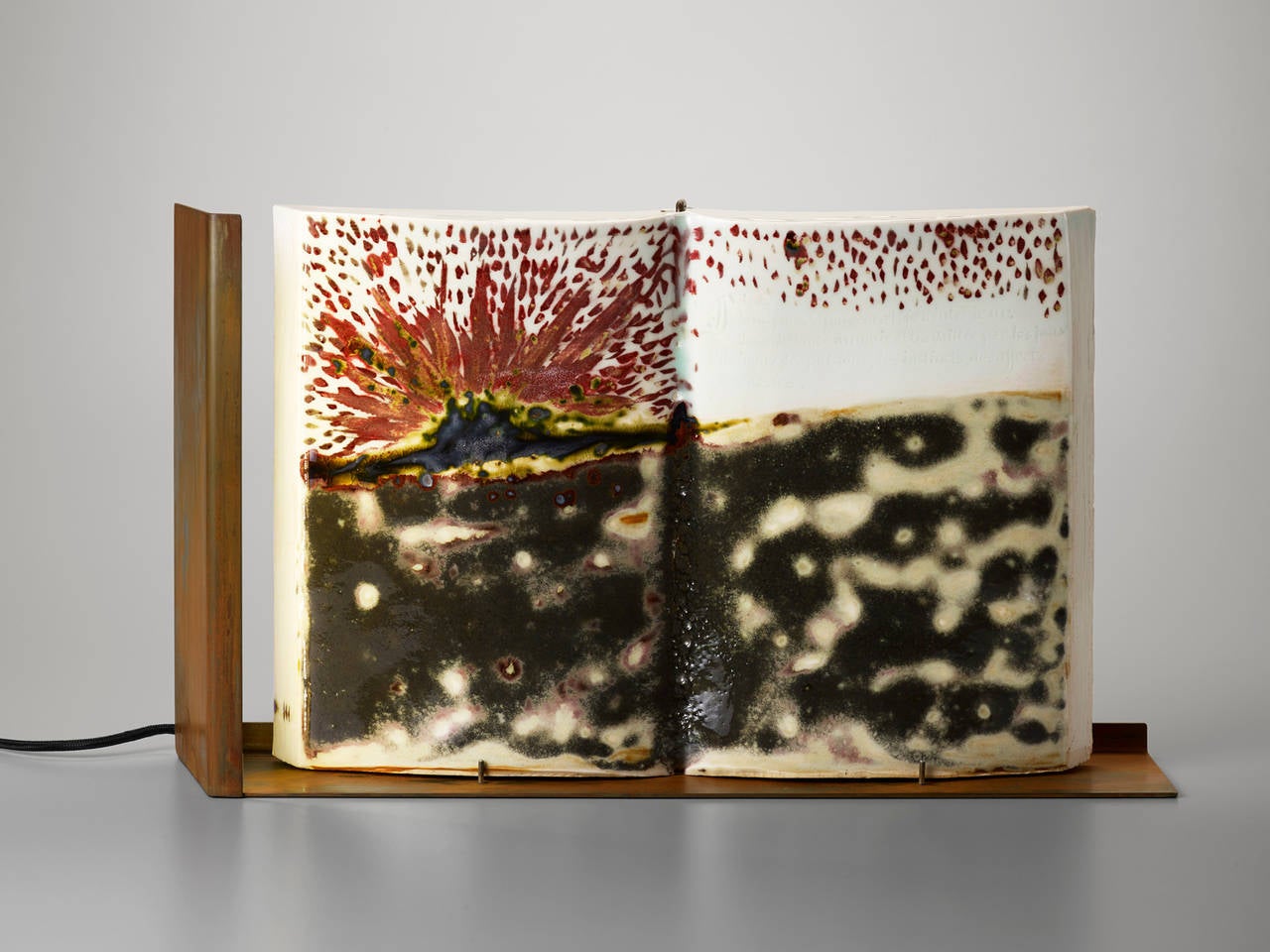 'Volcano Fire' is a unique handmade porcelain book and table lighting sculpture. It is part of the ‘Insomnio’ collection, a set of 21 striking porcelain books handmade by French visual artist Charlotte Cornaton, 28 years old, in the famous historic
