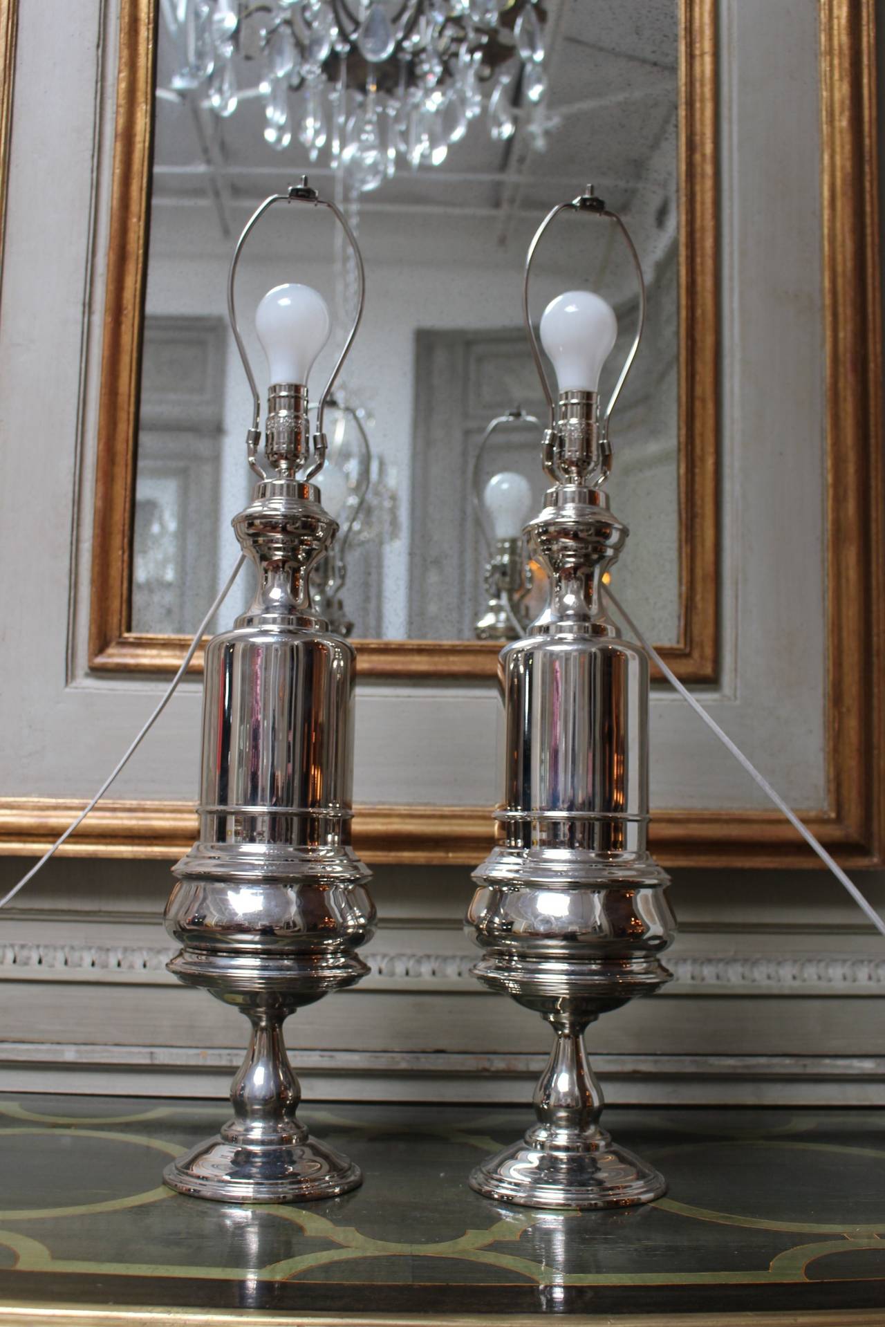 A pair of French 19th century lamp bases in nickel-plated bronze. They are in two pieces with the top resting on the lower base. These Mazarin style lamp bases were originally oil lamps and have been plated in the silver finish.