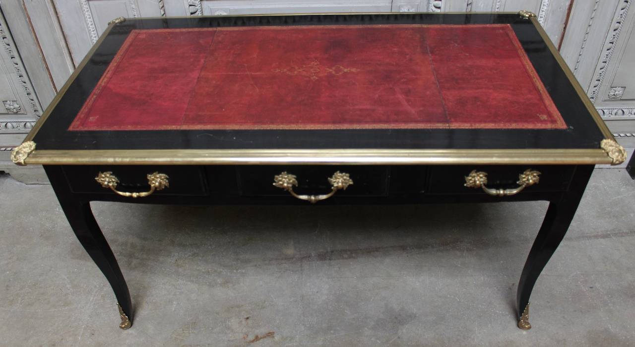 French Louis XV style black lacquered desk with a red tooled leather top and bronze hardware.