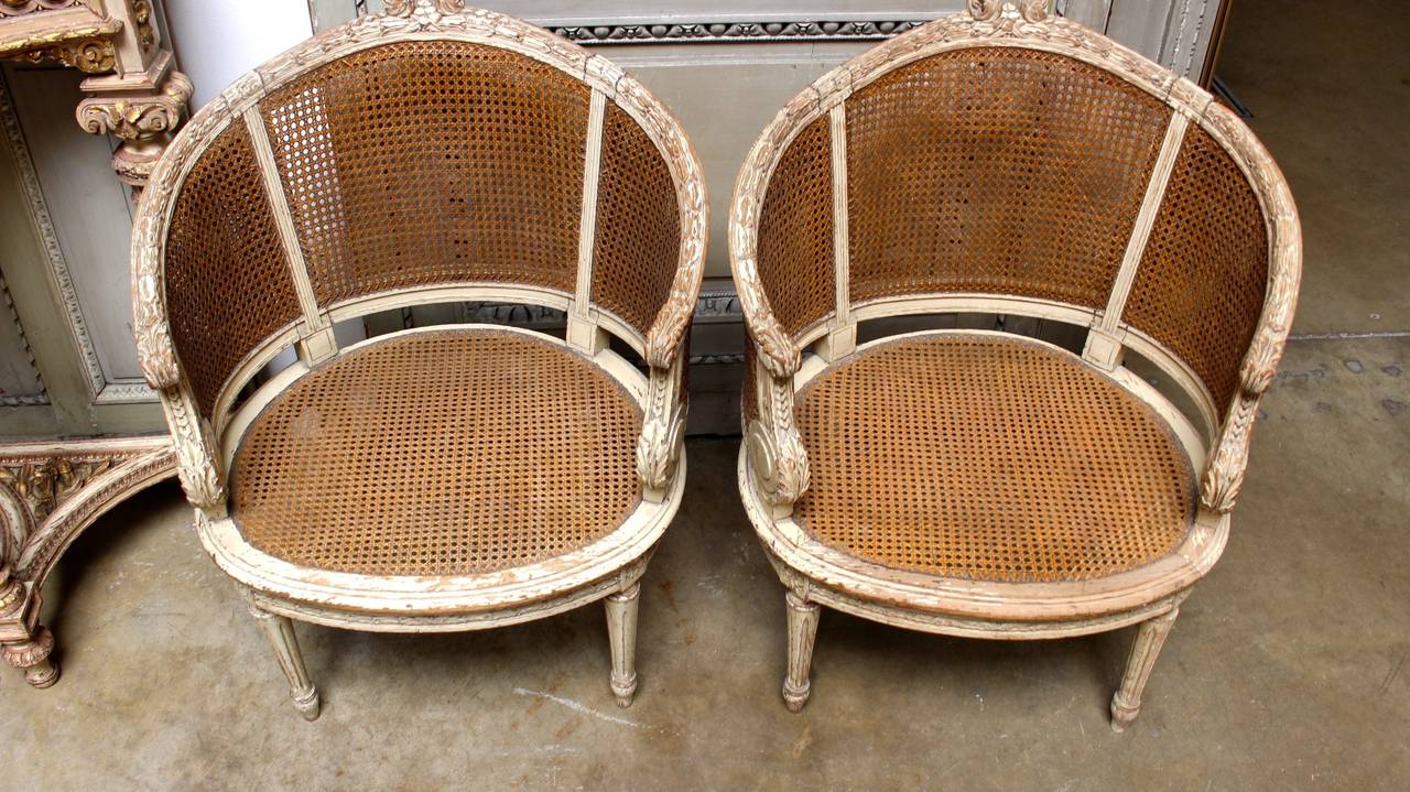 A Pair of French Louis XVI style caned bergeres with a painted finish