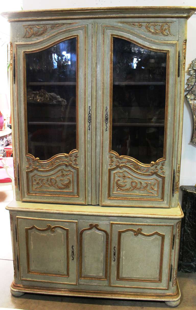 An 18th century painted and parcel-gilt French Regence bibliotheque with a later finish.