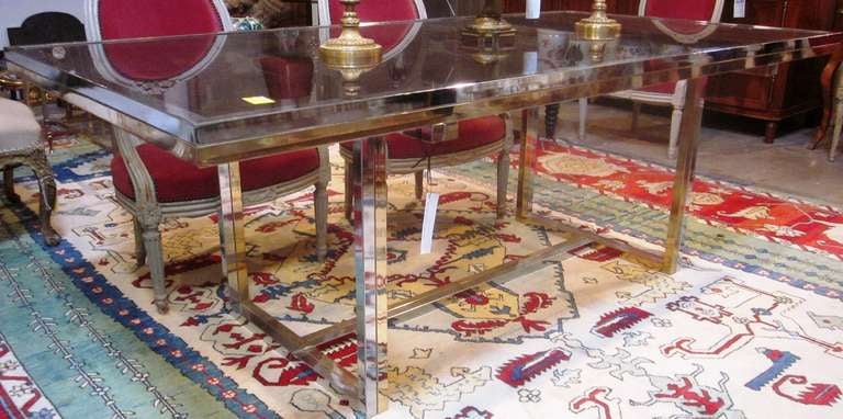 A French brass and chrome dining table with a smoked glass top.