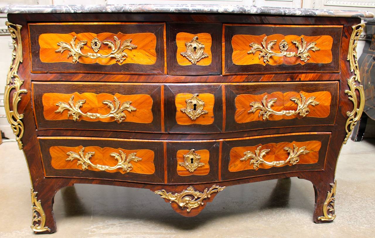 A French, Louis XV, four-drawer bronze-mounted commode with rosewood and kingwood with a marble top.