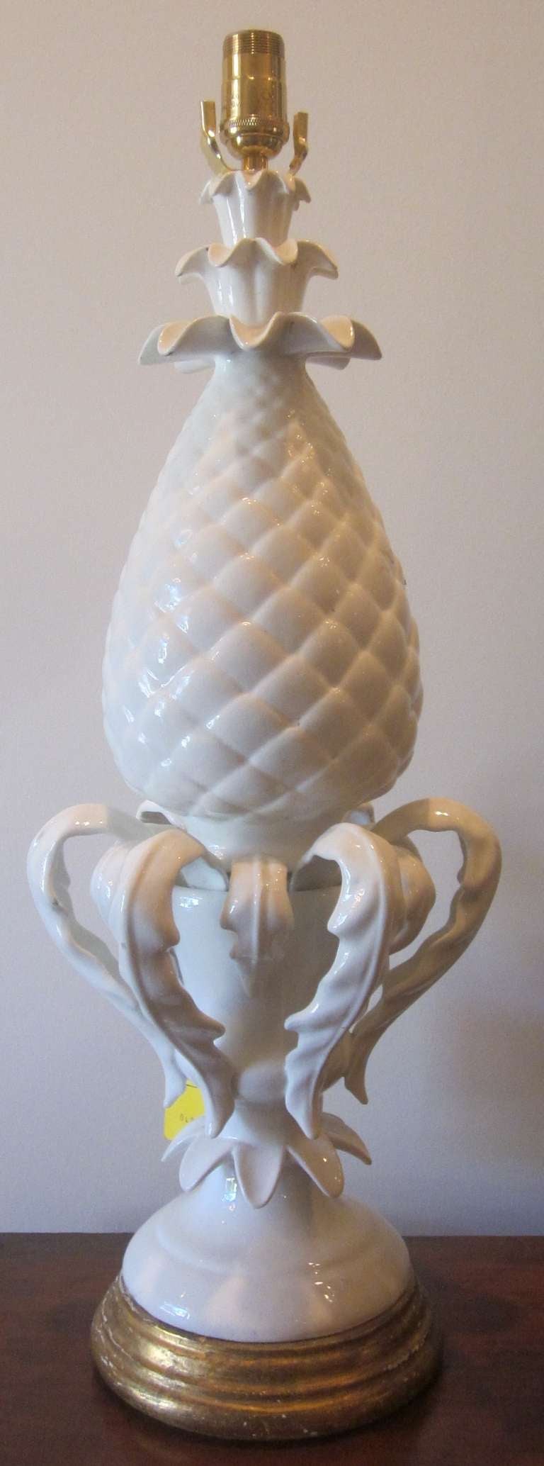 A Spanish white glazed pineapple table lamp with a giltwood base.