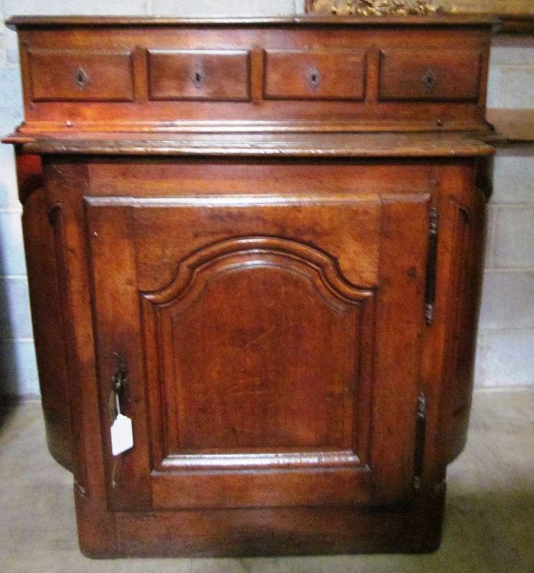 A French Regence period carved oak cabinet from the Burgundy region. This unusual cabinet could be used in many different places, as an entrance piece, a dining room serving and storage piece or in a large country kitchen or morning room. It has