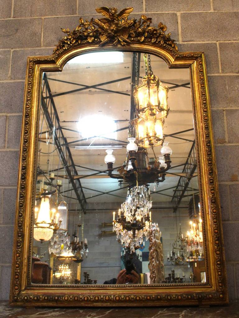 A French Louis XVI style mirror in a gold leaf finish. Late 19th century.