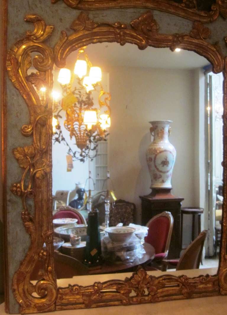 A French 19th century painted and parcel-gilt trumeau mirror.
A bucolic landscape is depicted and framed by gilt craved foliage.