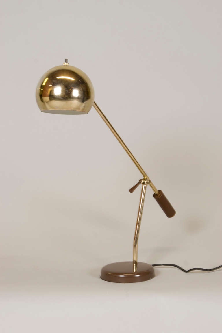 Exceptional desk lamp with an articulating arm and dome shade with brown handle and base.
