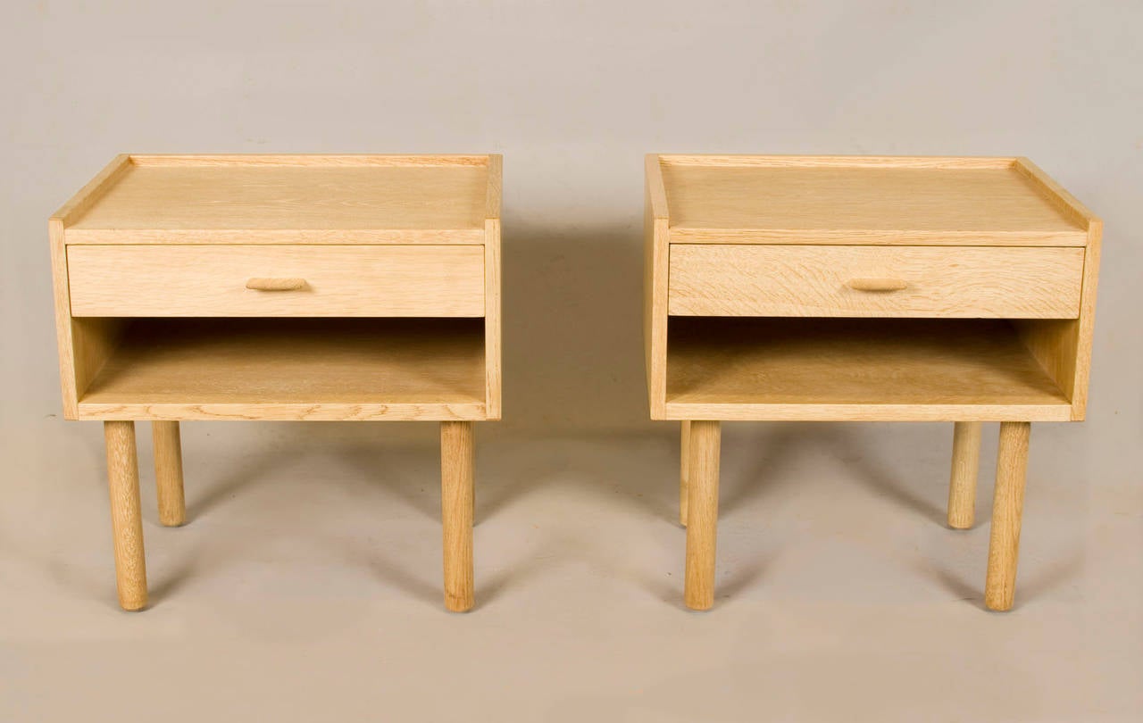 Pair of bleached white oak nightstands by Hans Wegner. Comprised of turned legs and single-drawer with wood pull. Signed with stamped manufacturer's mark to underside on both examples 