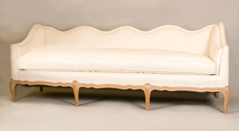 This Louis XV style sofa has a very comfortable single down cushion. Upholstered in white muslin supported with cabriole legs.