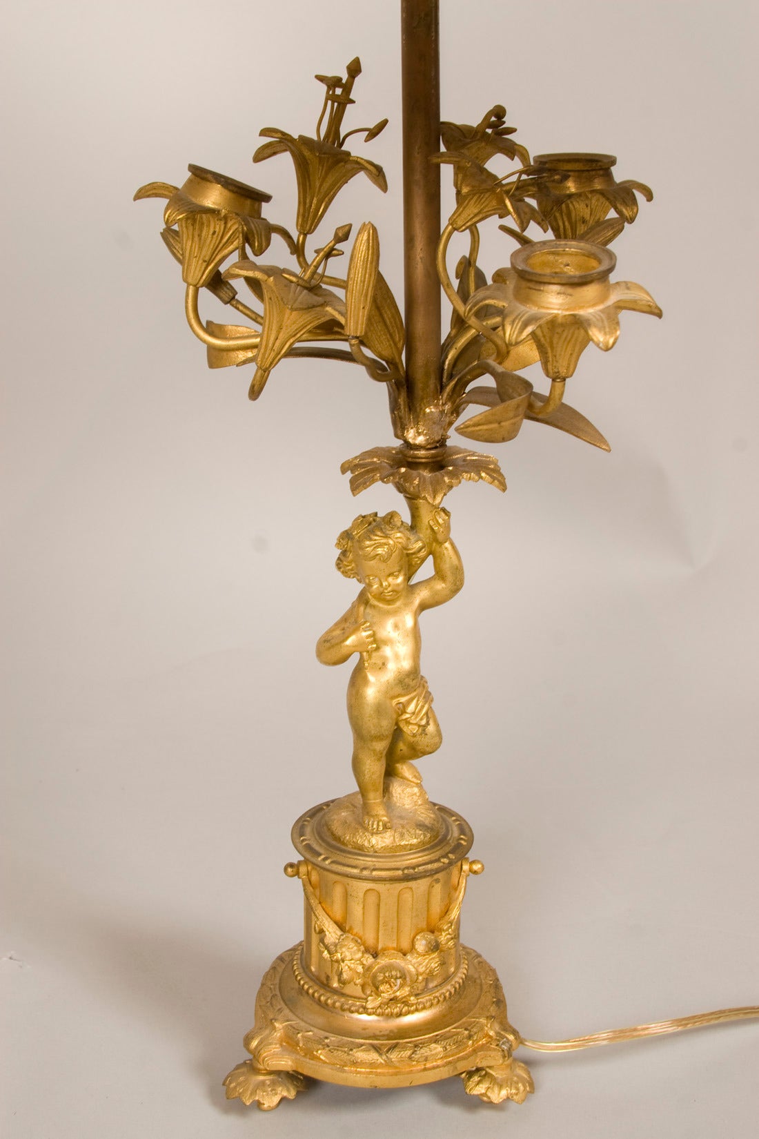 Gilt bronze lamp with cherubs and floral motifs. Candleholder converted into lamp.
Shade size: 15