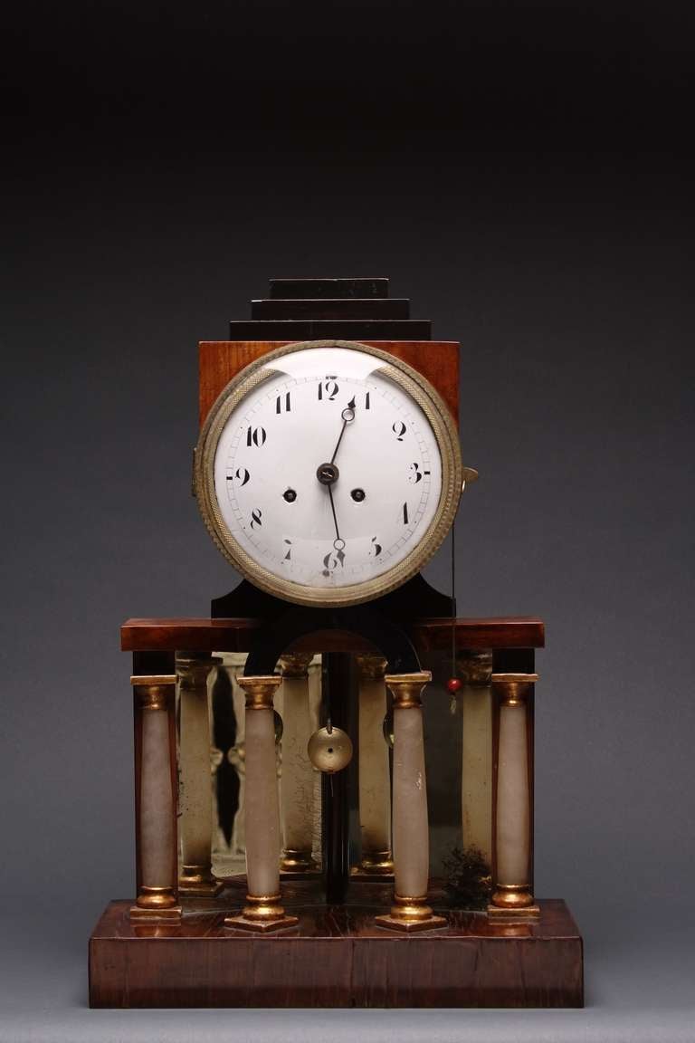 Une belle et très virile horloge de style néoclassique, en état de marche. Le boîtier est en acajou avec de l'ébène
détails, colonnes en albâtre avec garnitures en bronze, le tout devant un fond en verre miroir vieilli à trois panneaux.
C'est une