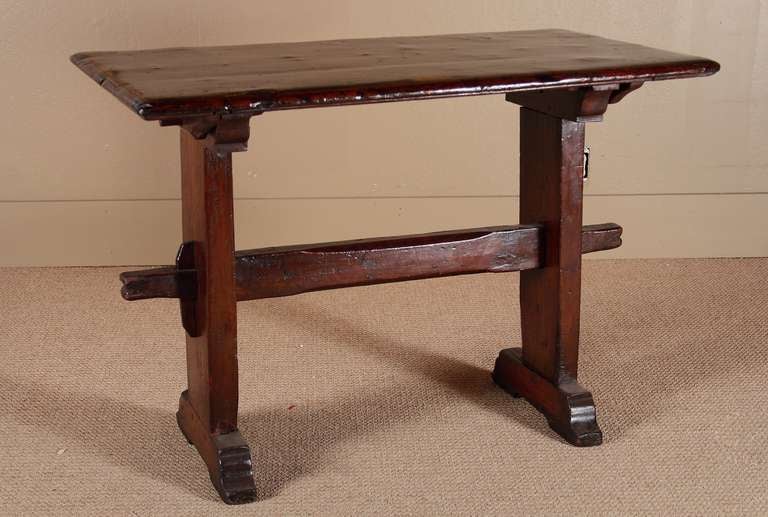 Continental early Baroque elmwood table with slight restorations. Beautiful patinated and undulated top and peg assembled base.