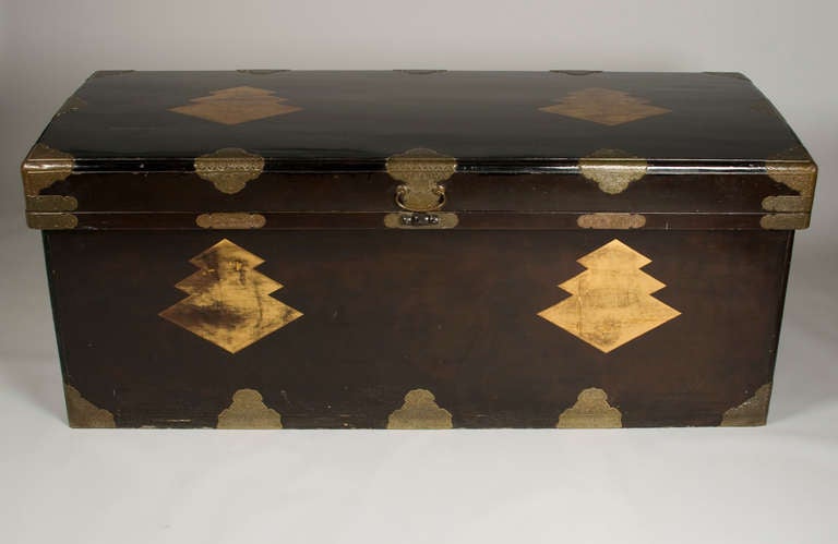 Superb Japanese lacquer trunk with gilt bronze fittings. A very large trunk with domed lid, decorative long bronze carrying handles and lined interior in Japanese paper in cream with gold specs.