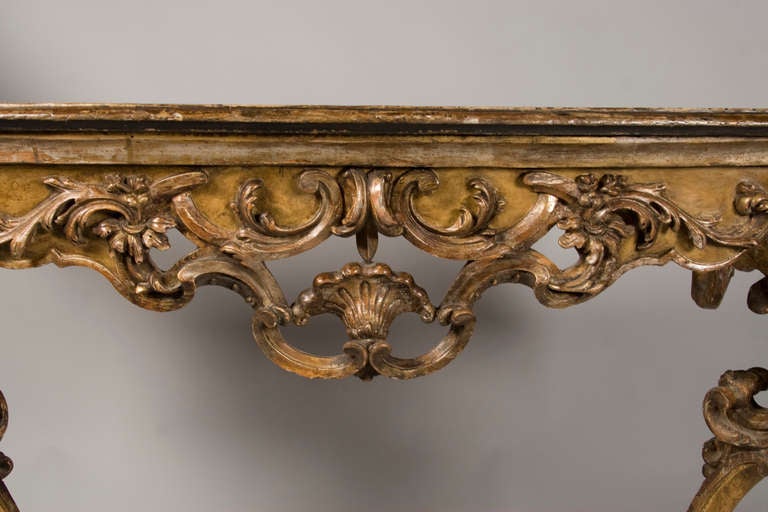 An Italian giltwood and ochre painted console, with doe foot detail. Fabulous flamboyant carving indicative of the Italian Rococo period. Very good faux 
marble top. Consoles of this caliber where produced thruout the centuries.