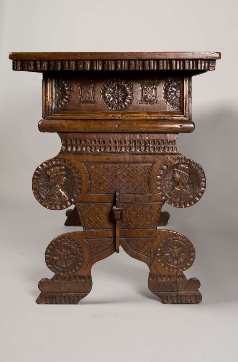 A rare and unusual console table or desk from the17th Century. Portuguese, chip carved. Beautiful carved medallions of noble women and men on top as well
 as on the outside of both trestle sides.
Some restorations. There is a drawer in the support
