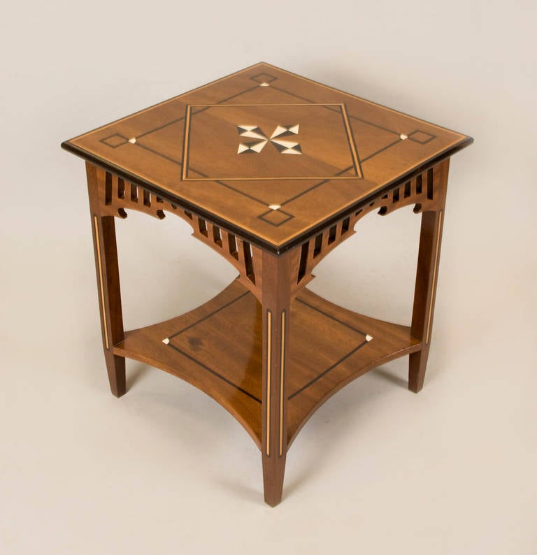 This beautiful Green and Green style craftsman side table is in very good
condition considering it's age. The inlay is ebony wood, bone and satin
wood stringer on legs. The fretwork carving on the apron is a beautiful
detail of the period.
The table