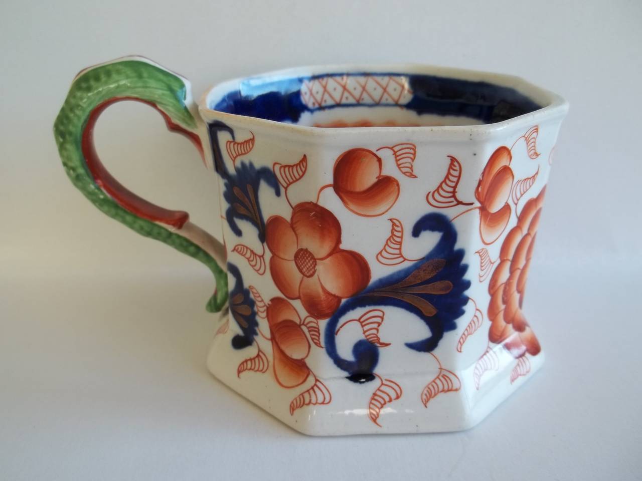 Early ironstone cider mugs are rare.

This one has an octagonal shape with a lovely high loop handle.

The mug has a good chinoiserie Imari pattern, hand-painted in bold enamels with additional gilded detail. There is also an inner rim