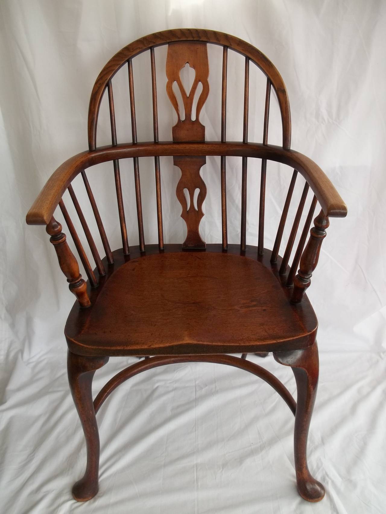 This is a good quality Country WINDSOR Arm Chair, made in England, possibly Thames Valley, in the mid 19th Century, or slightly earlier.

This chair has many good features with well carved high cabriole front legs and a crinoline stretcher. All