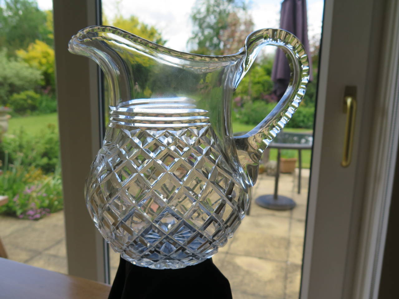 This is a high quality lead glass, crystal, water jug or pitcher dating to the late Georgian period of the early 19th century.

This jug is heavy (about 1.4 kg) and substantial holding well over two pints, with a nice light grey tone, typical of
