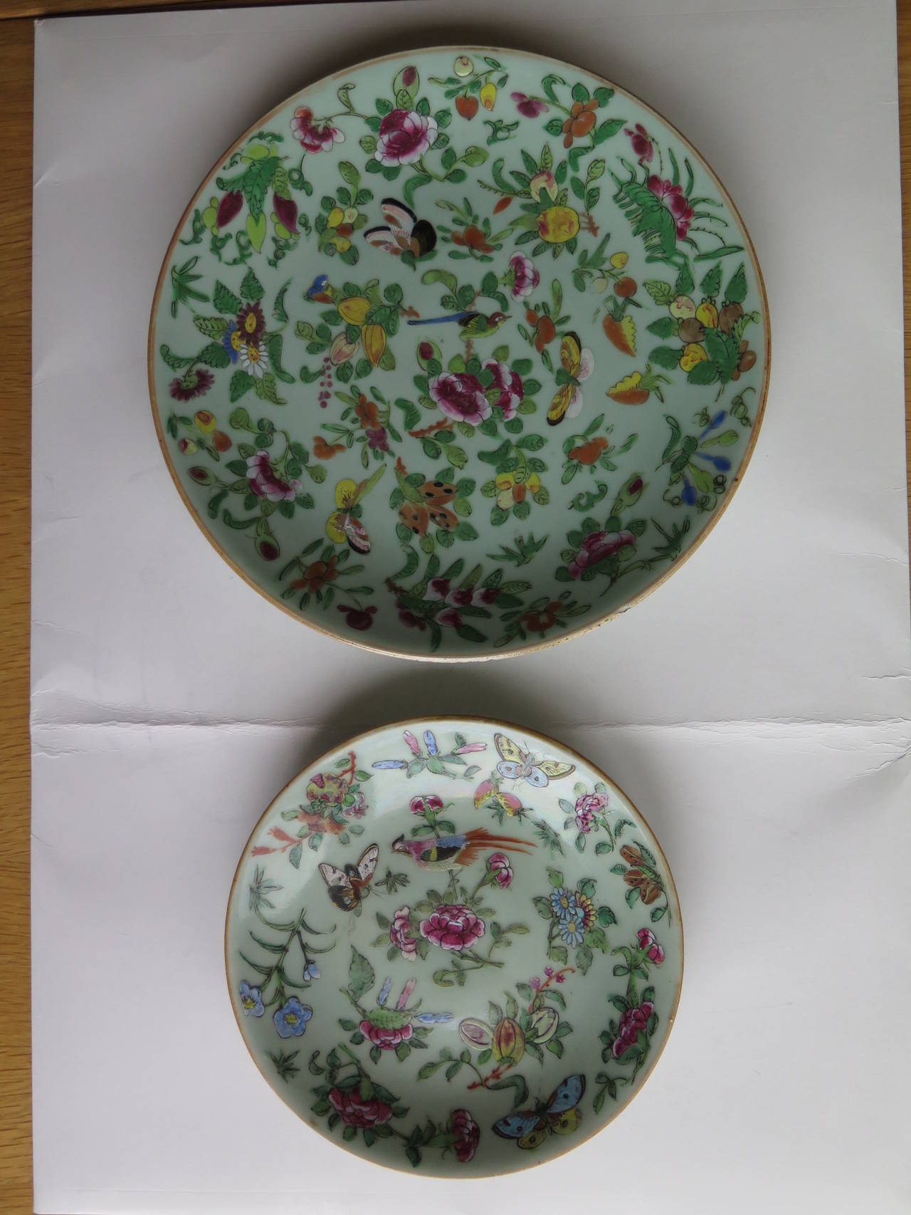 These are TWO 19th Century Chinese Export, (Canton) Plates or Dishes of different sizes.

Each plate has a light green, Celadon ground with beautifully hand painted   decoration, in over-glaze poly-chrome enamels of the Famille-Rose palette,