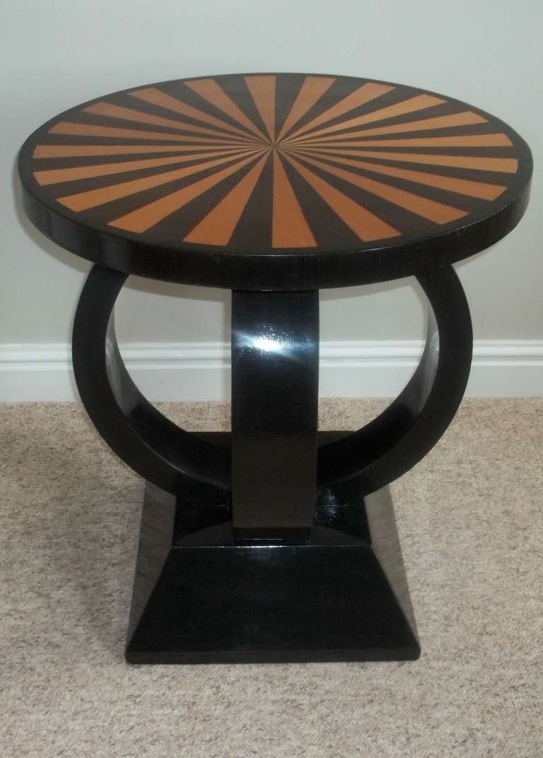This table is beautifully made, with a thick circular top having radiating alternating segments of contrasting exotic inlaid wood.
The edge is cross-banded.

The top sits on a cubist form column made up of two interlocking cylinders set at 180
