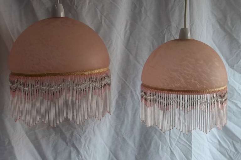 These are a beautiful matching  PAIR of LAMP SHADES.

They are made from a heavy and quite thick moulded glass which has a hemispherical shape, with a small out-turned edge The glass has a soft pink ground colour, decorated with a  marbled cloudy