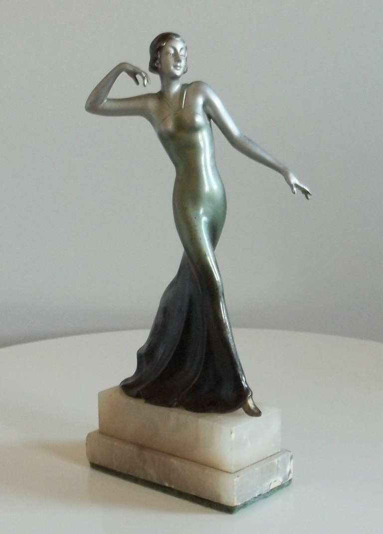 This is a very elegant and sought after cold painted, Bronze or Spelter (Bronze alloy) figurine of a lady in a long flowing ball gown, from the ART DECO period.

This is a fine quality figurine as It is very well sculpted with fine detail as shown