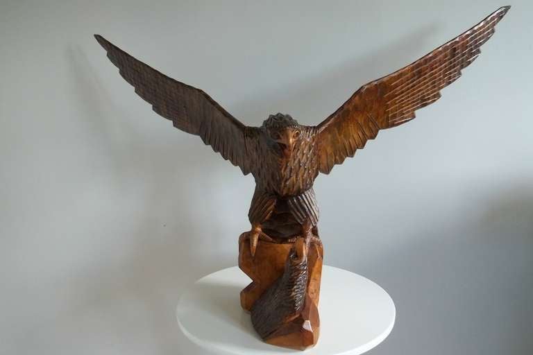 This is a very impressive and fine quality large hand carved wooden EAGLE with its EAGLET.

The carving has been made in three sections; the main body, the right hand wing and the left-hand wing. The carved detail is excellent and it has a lovely