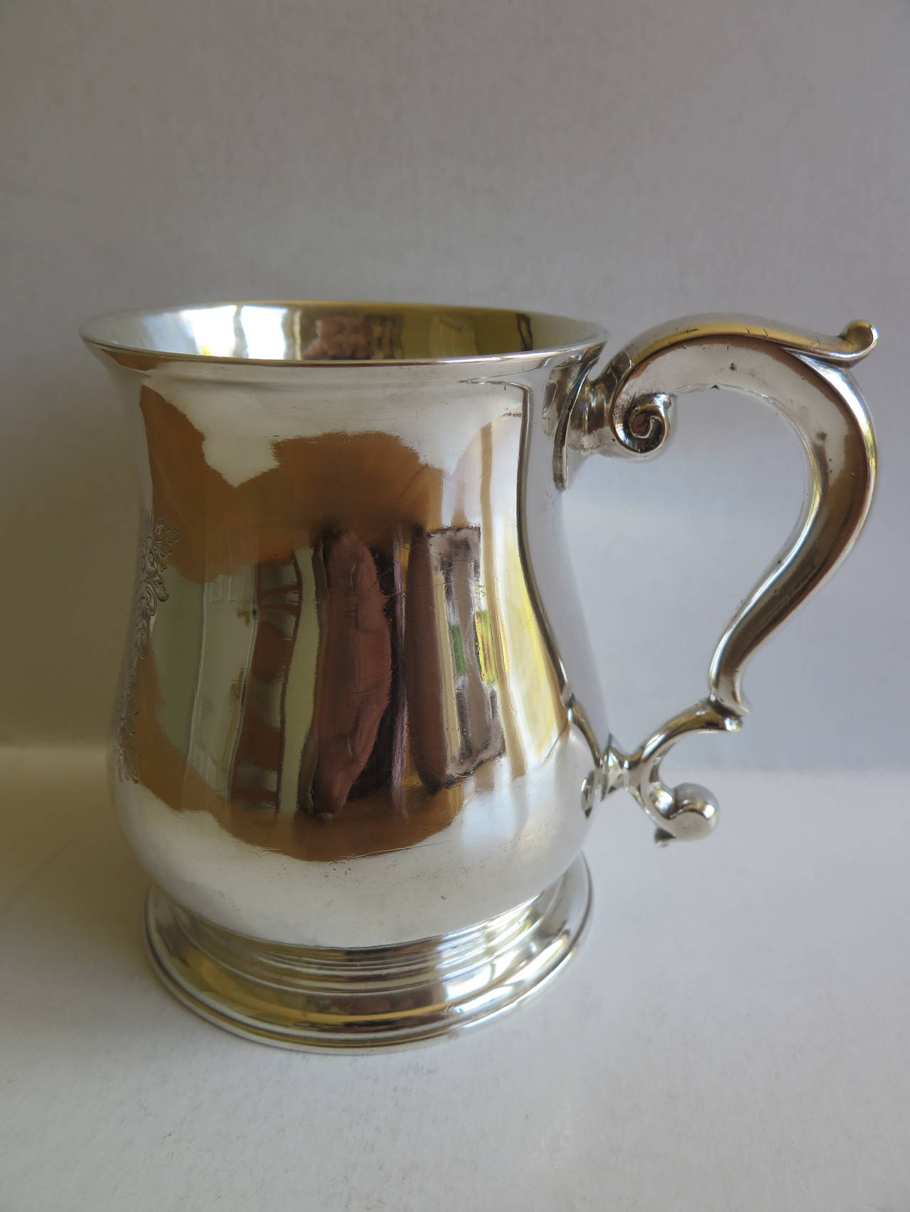 This is a fine English, Early Georgian, Sterling Silver Mug, made by Benjamin Cartwright, a silversmith of London, in 1735.

The mug has a classic baluster, pear shaped body with a slightly flaired rim, spreading foot with low pedestal and a double