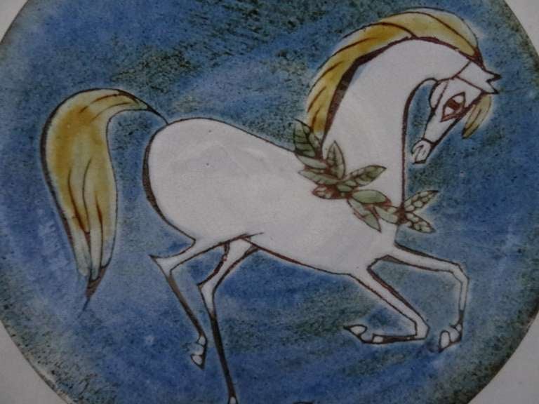 Chelsea Pottery plate depicting a white horse. Tinglaze earthenware pottery. 

Signed/Inscribed/Dated: Chelsea Pottery inscribed in script to base, the initials SC to the front of the dish.