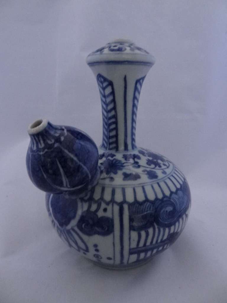 Porcelain Kendi,a drinking vessel designed to hold water or a liqour and for several people to be served by pouring the liquid from the spout. This example is in the style of, though later, decoration of the Wanli period (1573-1620). 

The vessel