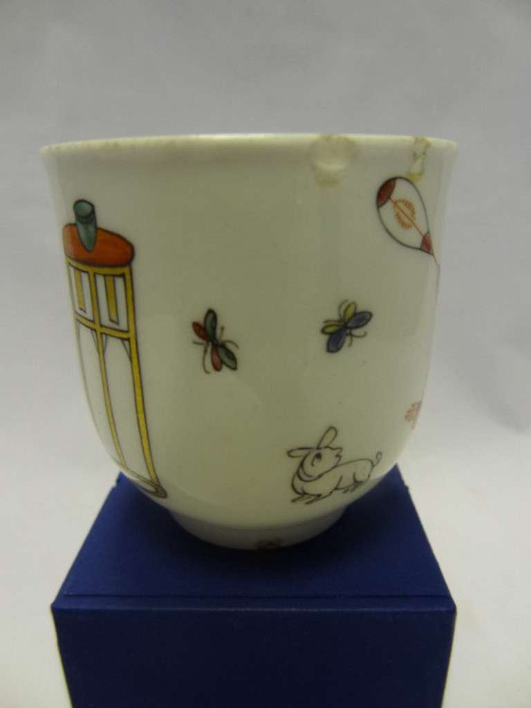 Porcelain Polychrome Coffee Cup 'The Chinese Family' with a Chinese mother and children with a kite, an animal in white, two insects, a table surmounted with a beaker, and a Chinese figure at a table. The position of the two insects varies by